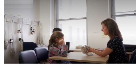 Dr. Lippé explaining the EEG cap to a child