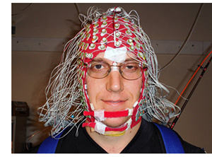 Dr. Ferris wearing an EEG cap in the lab of Dr. Scott Makeig